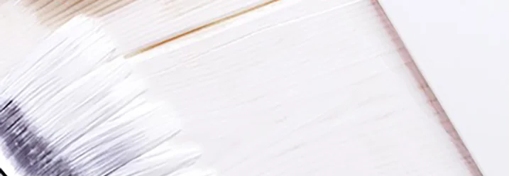 Pinsel trägt weiße Farbe auf Holz auf